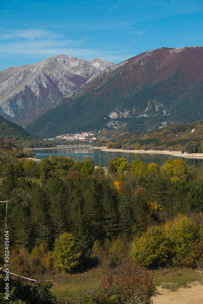 Fototapeta premium The beautiful colors of Lake Barrea in autumn season seen from the city of Barrea in the province of L'Aquila, Italy. One of the most beautiful landscapes of central Italy