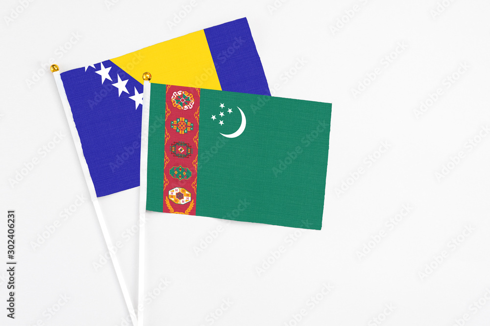Turkmenistan and Bosnia Herzegovina stick flags on white background. High quality fabric, miniature national flag. Peaceful global concept.White floor for copy space.