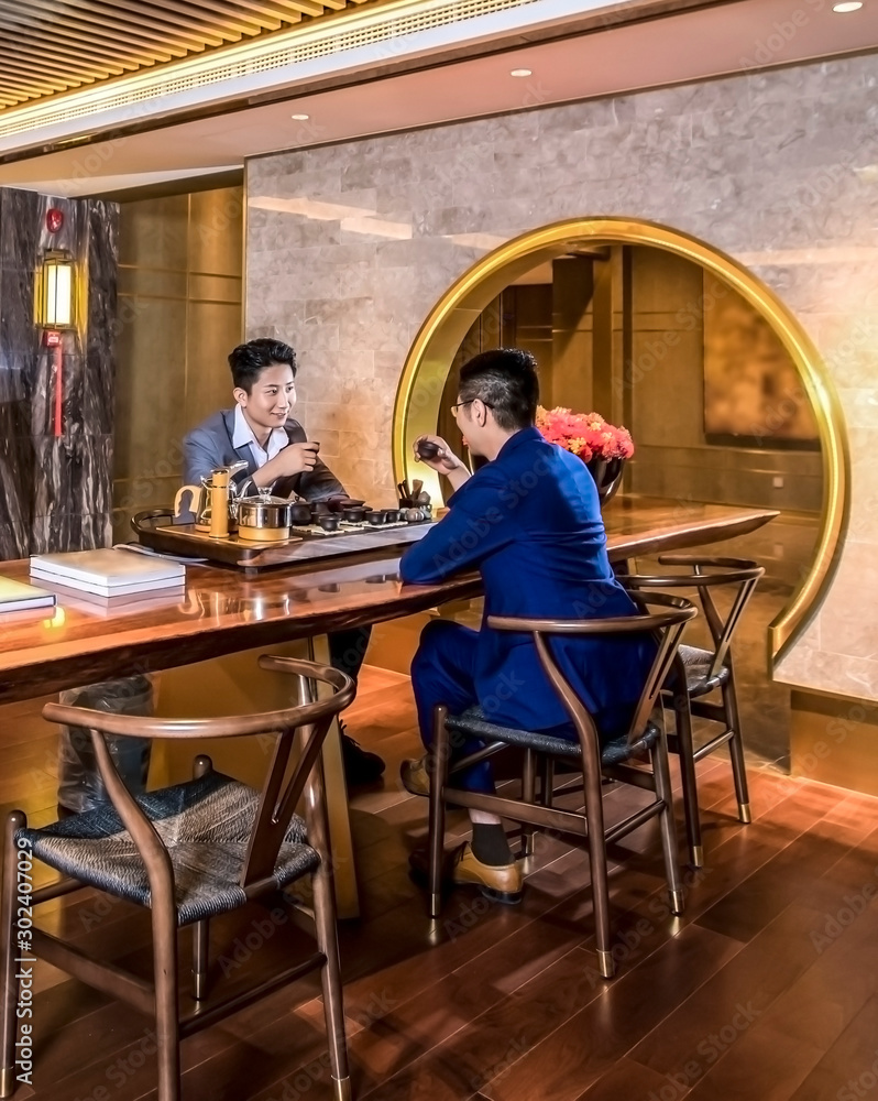 Two business Asian men drinking tea indoors