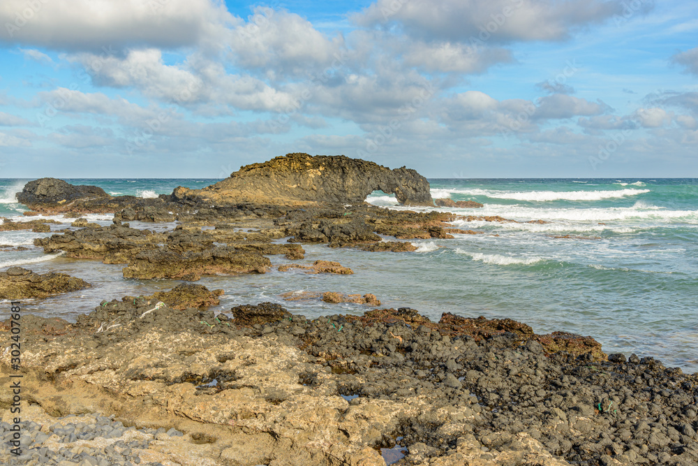 rocky seashore with rock bridges and waves
