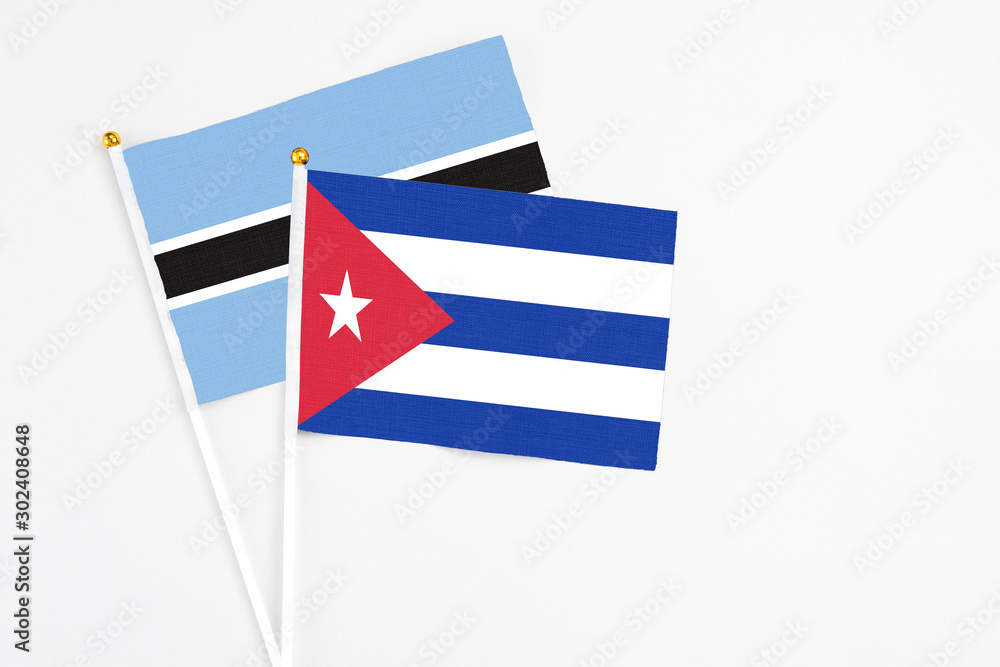 Cuba and Botswana stick flags on white background. High quality fabric, miniature national flag. Peaceful global concept.White floor for copy space. Cuba and Botswana stick flags on white background. High quality fabric, miniature national flag. Peaceful global concept.White floor for copy space.