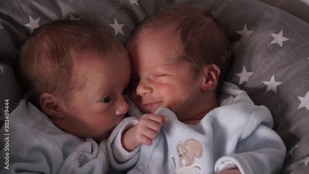 Twin babies lying down. Babies laughing. Newborn smile. - obrazy, fototapety, plakaty 