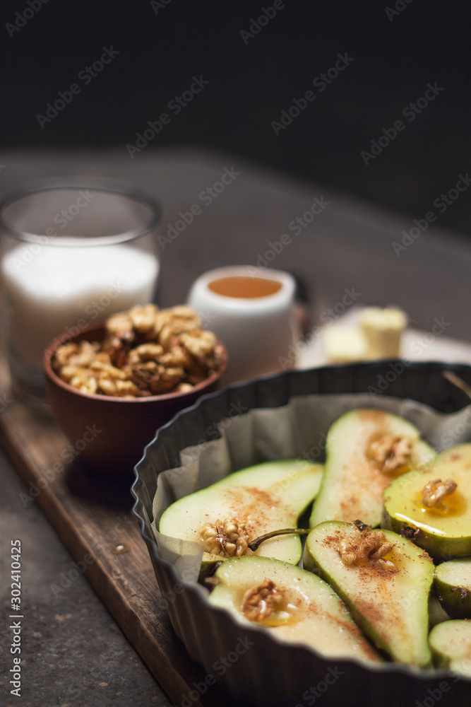 Pears are prepared for baking in the oven. The process of cooking baked fruits with cinnamon, nuts and honey Pears are prepared for baking in the oven. The process of cooking baked fruits with cinnamon, nuts and honey