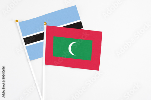 Maldives and Botswana stick flags on white background. High quality fabric, miniature national flag. Peaceful global concept.White floor for copy space.
