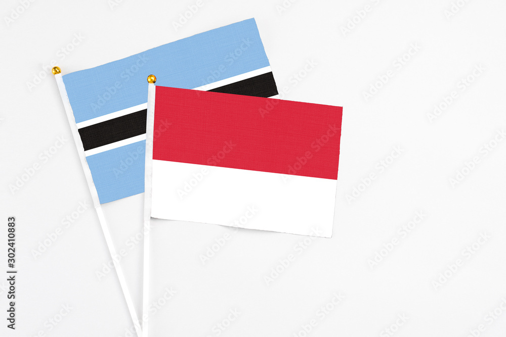 Monaco and Botswana stick flags on white background. High quality fabric, miniature national flag. Peaceful global concept.White floor for copy space. Monaco and Botswana stick flags on white background. High quality fabric, miniature national flag. Peaceful global concept.White floor for copy space.