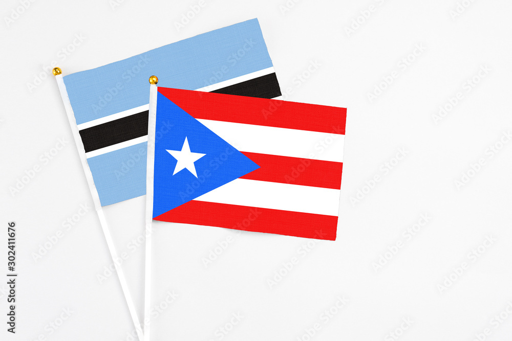 Puerto Rico and Botswana stick flags on white background. High quality fabric, miniature national flag. Peaceful global concept.White floor for copy space. Puerto Rico and Botswana stick flags on white background. High quality fabric, miniature national flag. Peaceful global concept.White floor for copy space.