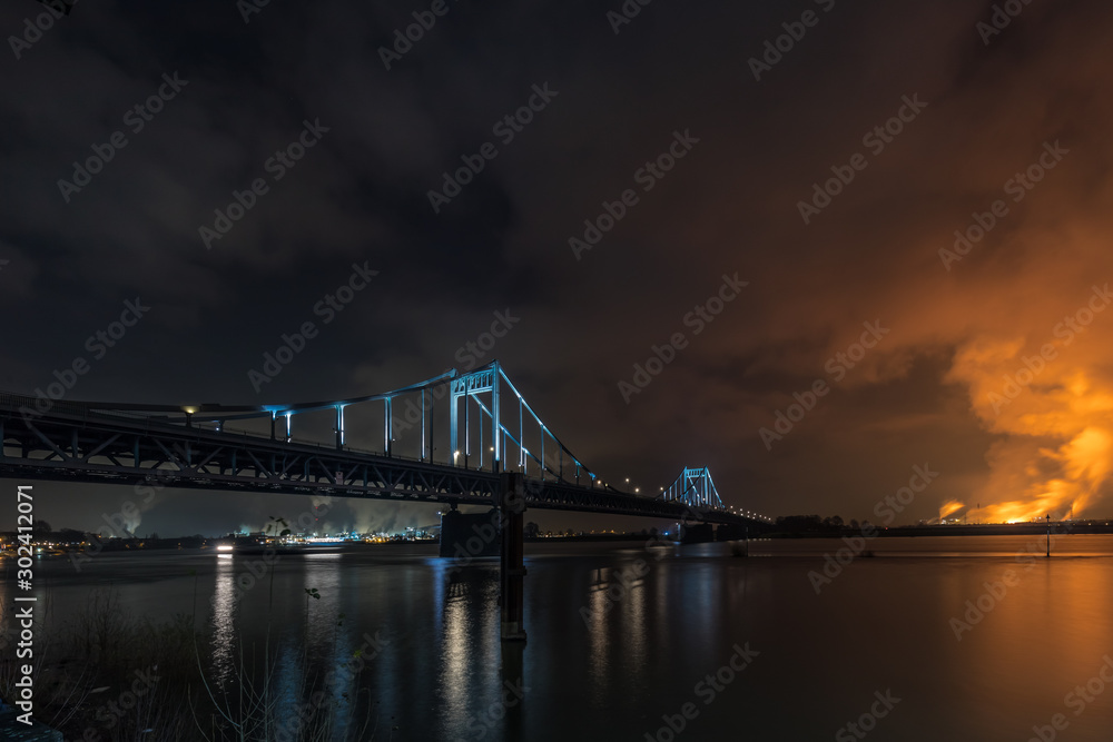 Illuminated Historical Iron Bridge across the River Rhine connecting Duisburg and Krefeld Uerdingen At Night