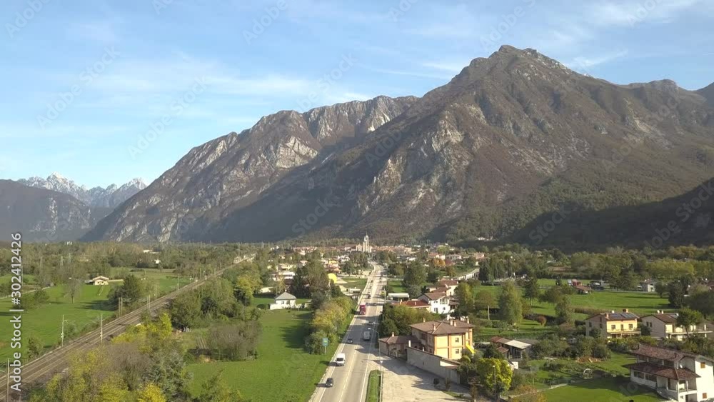 Aerial view of a small historic town Venzone in Northern Italy with red tiled roofs of old buildings and majestic Alps mountains. Aerial view of a small historic town Venzone in Northern Italy with red tiled roofs of old buildings and majestic Alps mountains.
