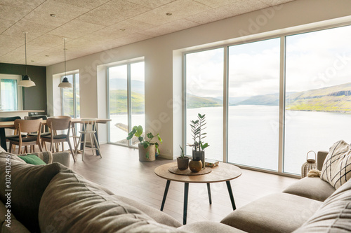 Faroese living room with big window and view on fjord. Scandinavian modern interior. photo