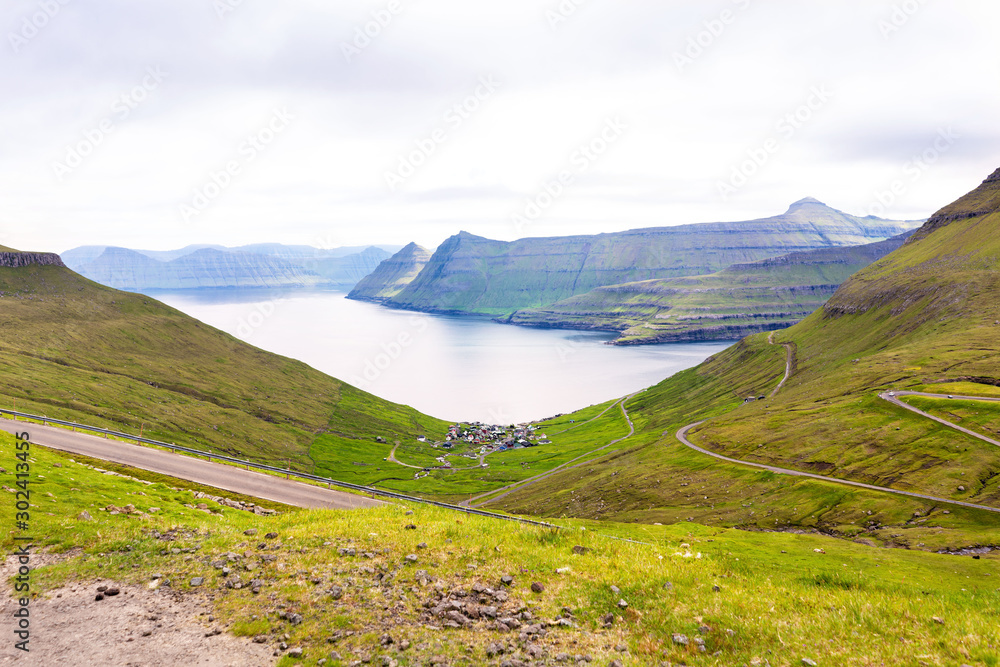 Faroese landscape with fjord bay and green mountains.