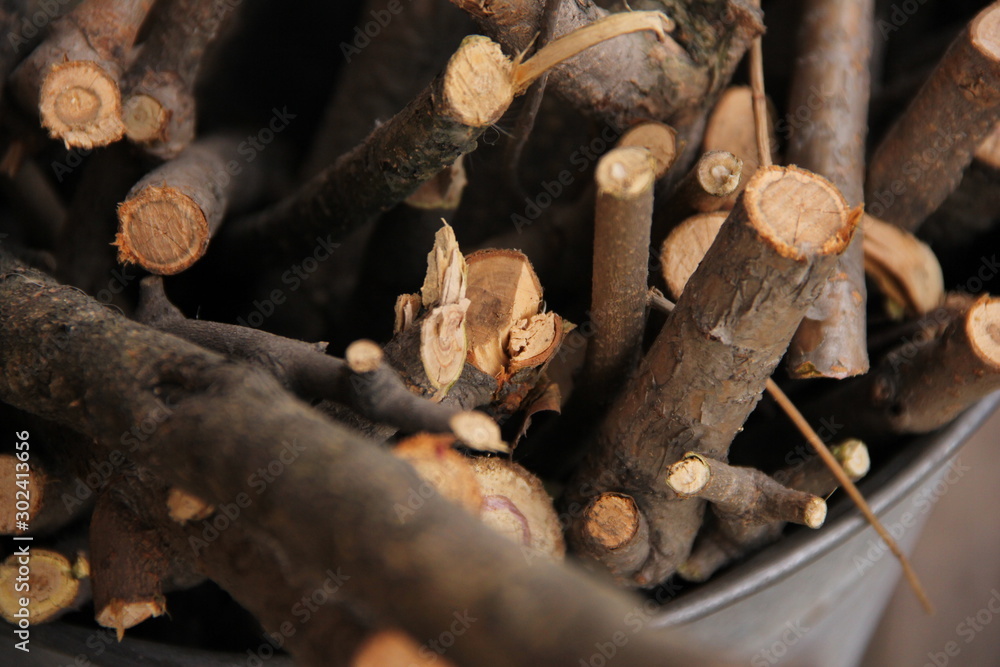 brushwood in a bucket for a stove or fireplace near a brick wall. Old firewood basket on a rustic wooden floor brushwood in a bucket for a stove or fireplace near a brick wall. Old firewood basket on a rustic wooden floor