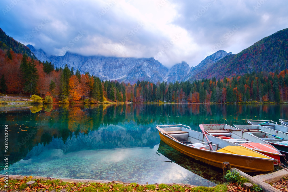Alpine lake and colorful boats, Lake Fusine,Italy - obrazy, fototapety, plakaty 