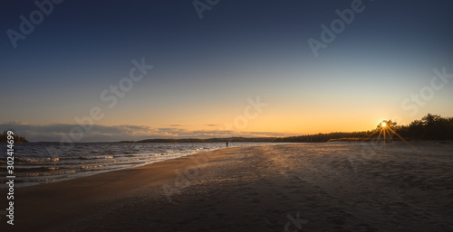 Unrecognizable man walks the beach line. Panorama of northern sand shore © kovaleva_ka