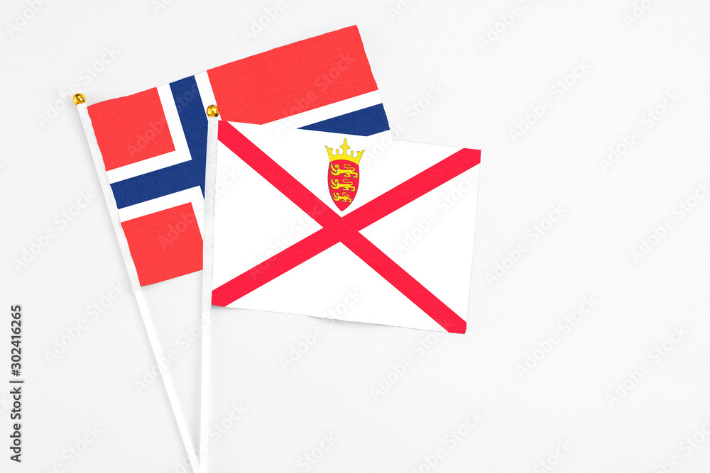 Jersey and Bouvet Islands stick flags on white background. High quality fabric, miniature national flag. Peaceful global concept.White floor for copy space. Jersey and Bouvet Islands stick flags on white background. High quality fabric, miniature national flag. Peaceful global concept.White floor for copy space.