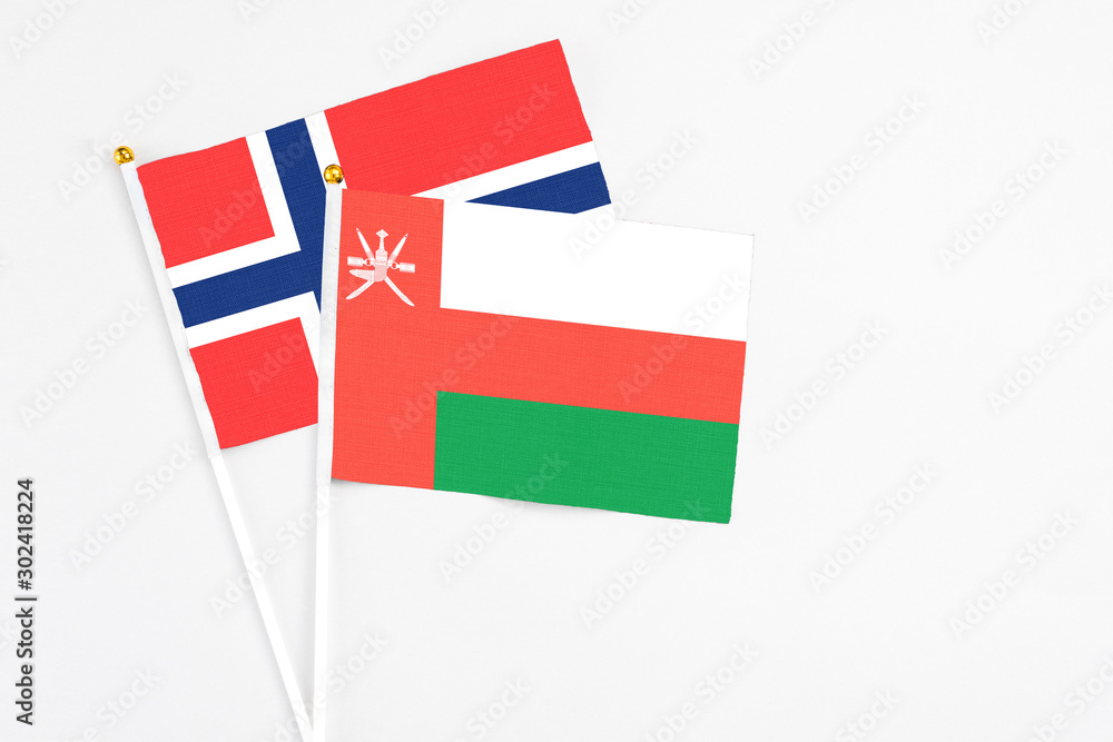 Oman and Bouvet Islands stick flags on white background. High quality fabric, miniature national flag. Peaceful global concept.White floor for copy space. Oman and Bouvet Islands stick flags on white background. High quality fabric, miniature national flag. Peaceful global concept.White floor for copy space.