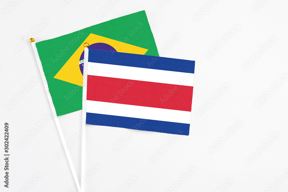Costa Rica and Brazil stick flags on white background. High quality fabric, miniature national flag. Peaceful global concept.White floor for copy space. Costa Rica and Brazil stick flags on white background. High quality fabric, miniature national flag. Peaceful global concept.White floor for copy space.