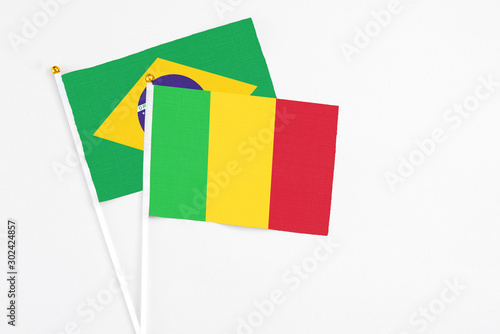 Mali and Brazil stick flags on white background. High quality fabric, miniature national flag. Peaceful global concept.White floor for copy space.
