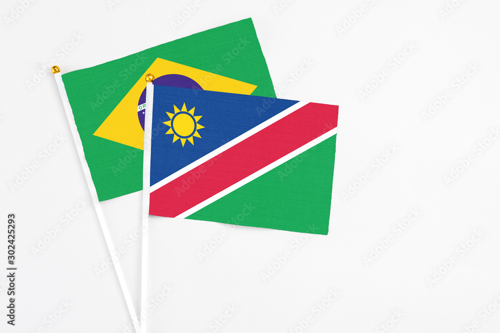 Fototapeta premium Namibia and Brazil stick flags on white background. High quality fabric, miniature national flag. Peaceful global concept.White floor for copy space.