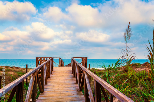 landscape of Public Beach access. view of Boardwalk with fences over the dunes