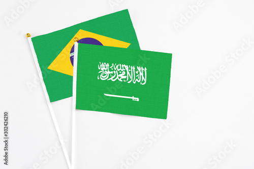 Saudi Arabia and Brazil stick flags on white background. High quality fabric, miniature national flag. Peaceful global concept.White floor for copy space.
