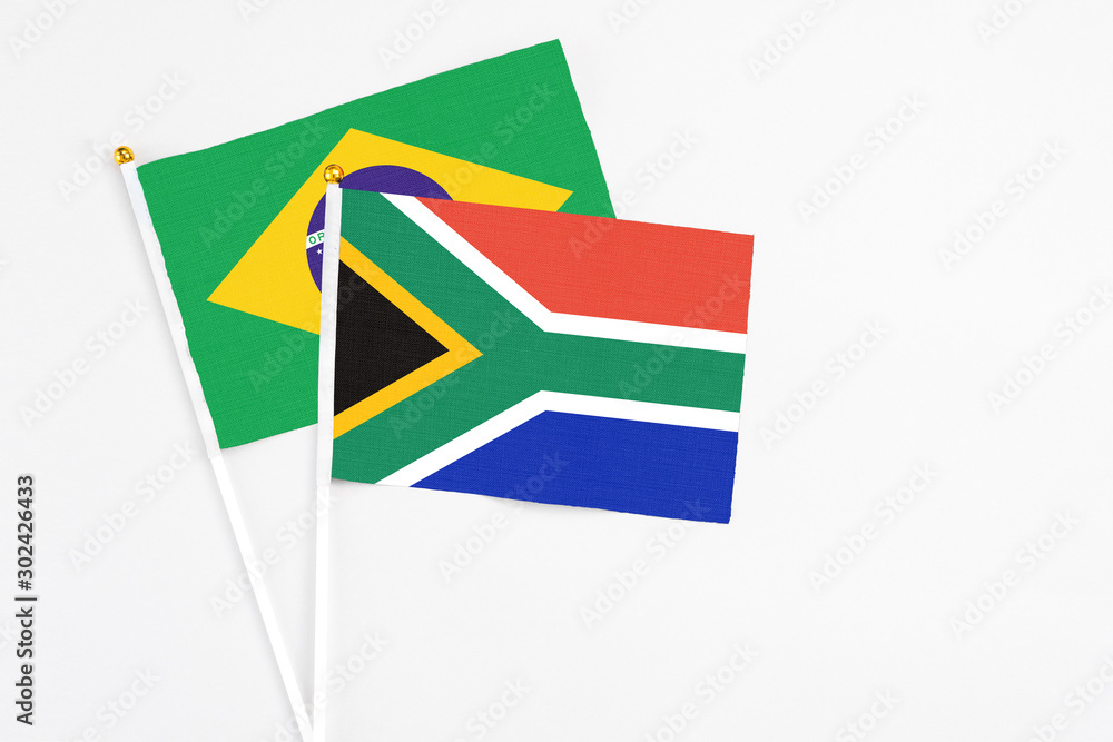 Fototapeta premium South Africa and Brazil stick flags on white background. High quality fabric, miniature national flag. Peaceful global concept.White floor for copy space.