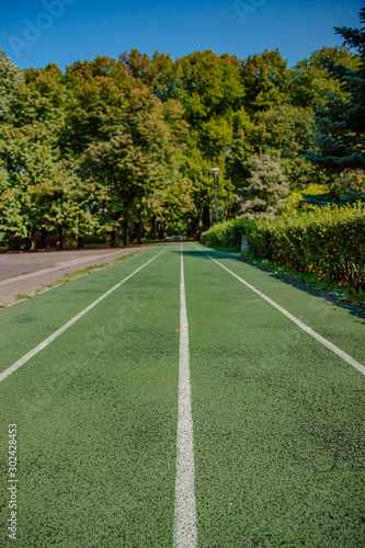 Treadmill in sport field with green grass and sunlight. © liubovyashkir