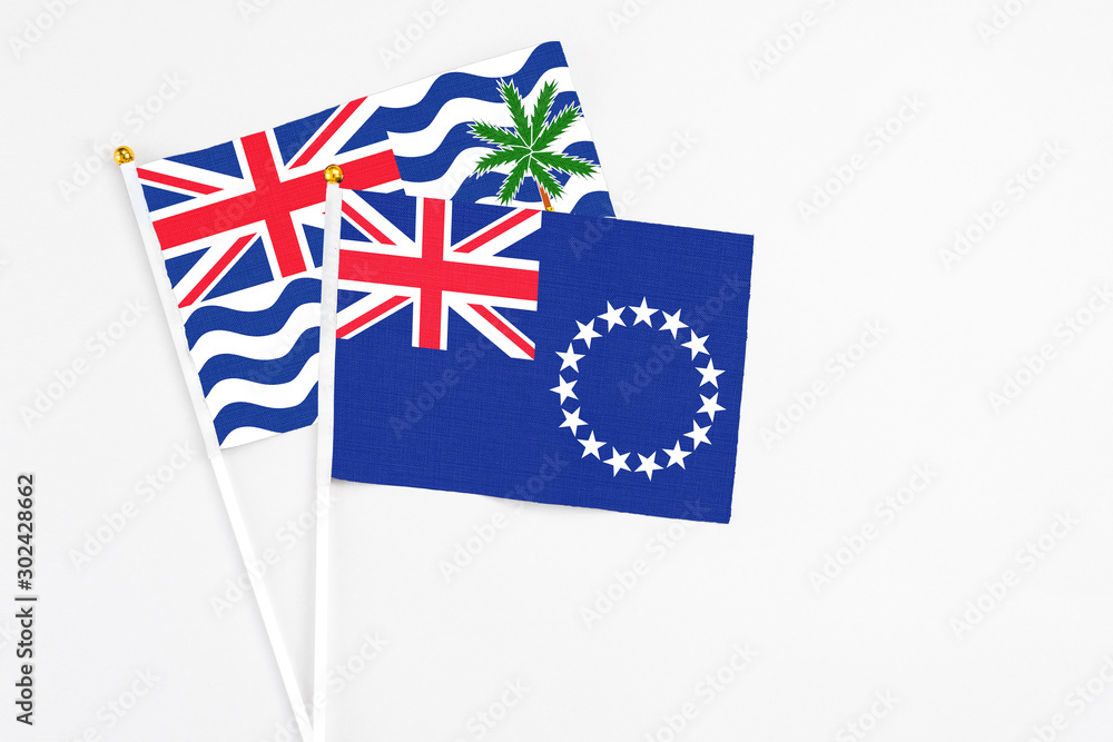 Fototapeta premium Cook Islands and British Indian Ocean Territory stick flags on white background. High quality fabric, miniature national flag. Peaceful global concept.White floor for copy space.