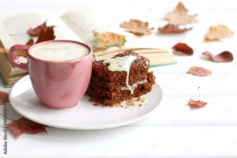 cake with a cup of coffee on a background of books and leaves on the table. sweet warming autumn cake with a cup of coffee on a background of books and leaves on the table. sweet warming autumn
