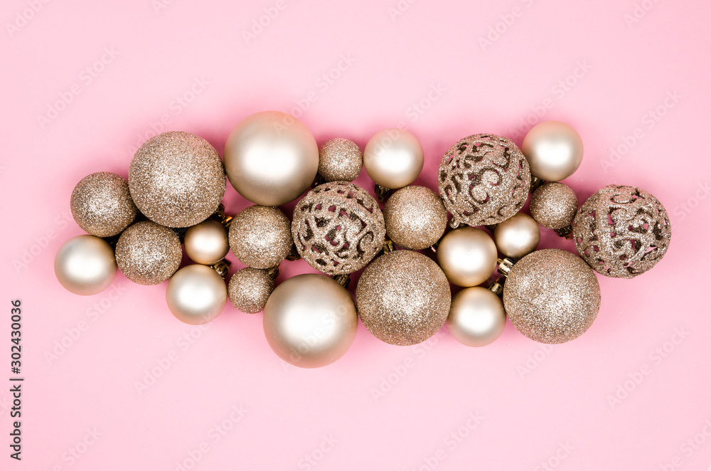 Christmas composition maate gold balls and Xmas decorations on a pink background. Top view flat lay