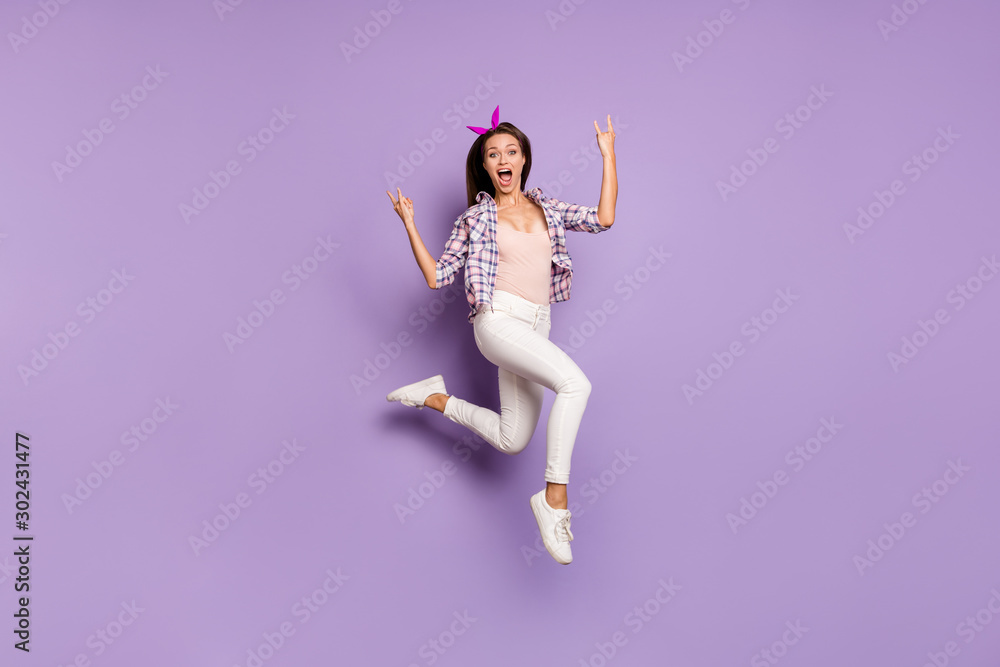 Full length body size view of her she nice attractive cheerful cheery funky overjoyed girl jumping having fun showing horns sign isolated on violet purple lilac pastel color background