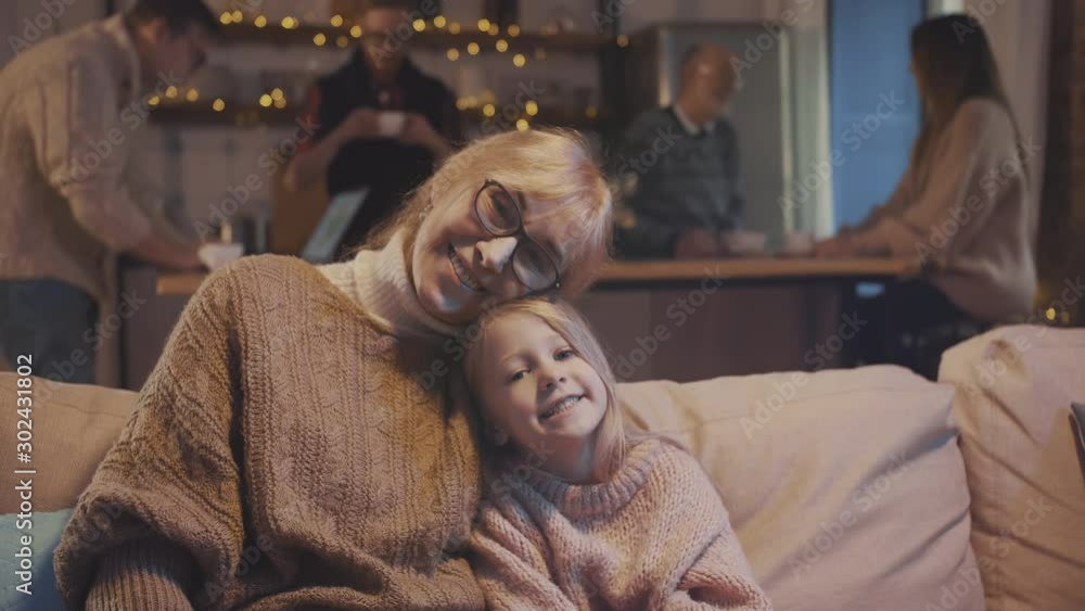 Smiling granddaughter hugging with grandma at Christmas. Family celebrating thanksgiving together Smiling granddaughter hugging with grandma at Christmas. Family celebrating thanksgiving together