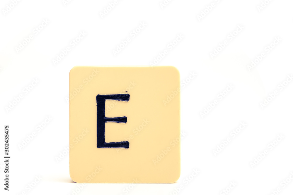 Dark letter E on a pale yellow square block isolated on white background Dark letter E on a pale yellow square block isolated on white background