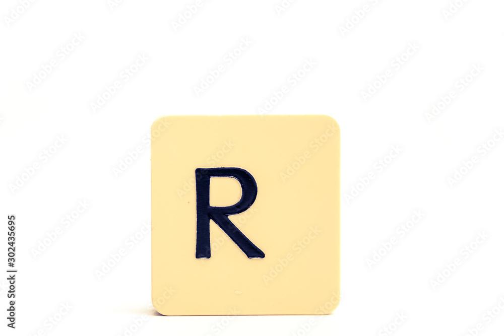 Dark letter R on a pale yellow square block isolated on white background Dark letter R on a pale yellow square block isolated on white background