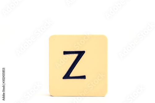 Dark letter Z on a pale yellow square block isolated on white background