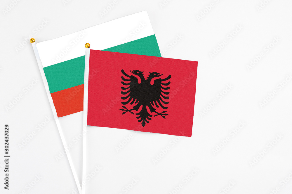 Albania and Bulgaria stick flags on white background. High quality fabric, miniature national flag. Peaceful global concept.White floor for copy space.
