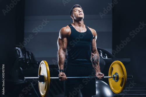 Handsome strong athletic men pumping up biceps muscles workout fitness and bodybuilding concept background - muscular bodybuilder fitness men doing arms exercises in gym naked torso.