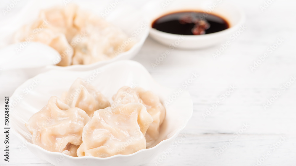Fresh, delicious boiled pork, shrimp gyoza dumplings on white background with soy sauce and chopsticks, close up, lifestyle. Homemade design concept. Fresh, delicious boiled pork, shrimp gyoza dumplings on white background with soy sauce and chopsticks, close up, lifestyle. Homemade design concept.