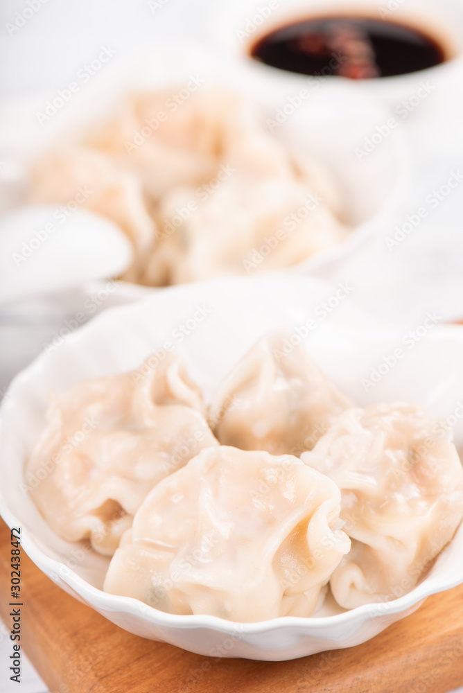 Fresh, delicious boiled pork, shrimp gyoza dumplings on white background with soy sauce and chopsticks, close up, lifestyle. Homemade design concept. Fresh, delicious boiled pork, shrimp gyoza dumplings on white background with soy sauce and chopsticks, close up, lifestyle. Homemade design concept.