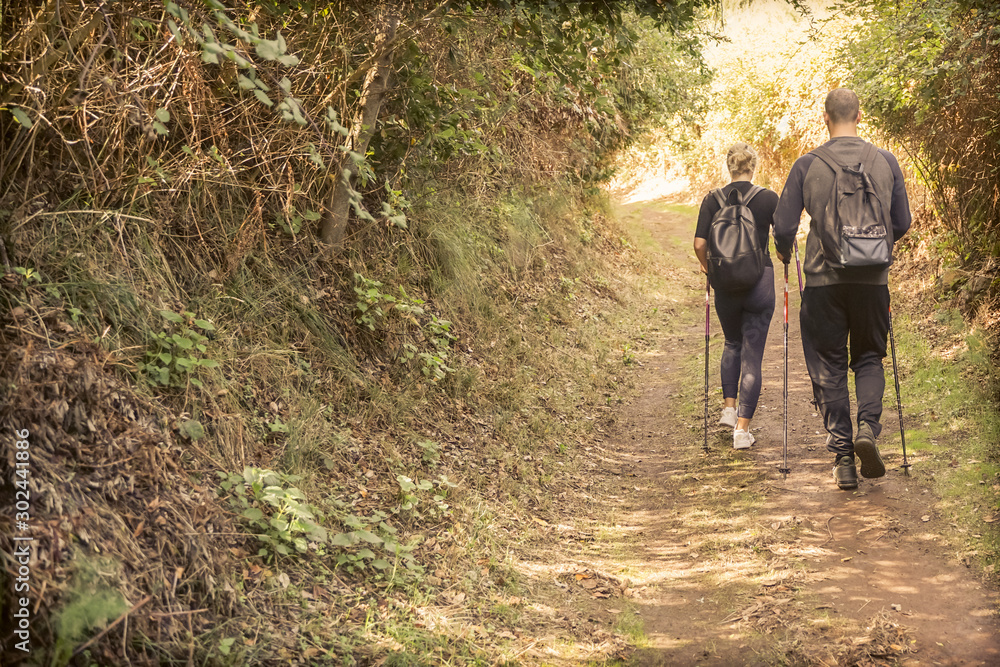 Young couple doing trekking excursion. People walking in nature outdoor. Survival,travel and adventure concept - Image Young couple doing trekking excursion. People walking in nature outdoor. Survival,travel and adventure concept - Image