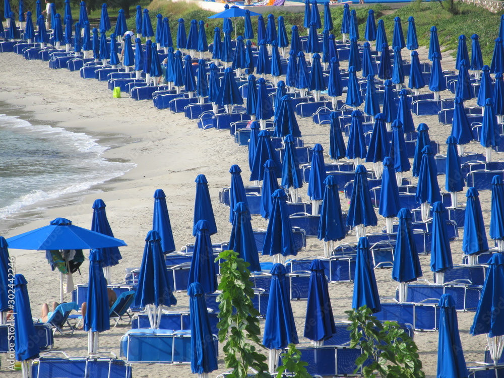 Fototapeta premium lowered blue beach umbrellas. the concept of the end of the beach season