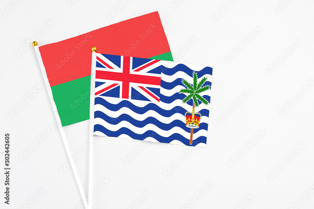 Fototapeta premium British Indian Ocean Territory and Burkina Faso stick flags on white background. High quality fabric, miniature national flag. Peaceful global concept.White floor for copy space.