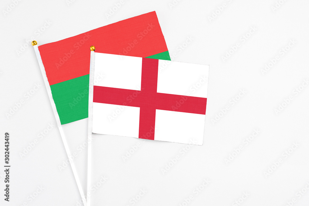 England and Burkina Faso stick flags on white background. High quality fabric, miniature national flag. Peaceful global concept.White floor for copy space.