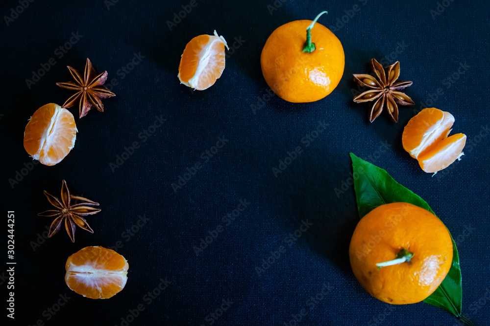 Dark textured christmas background with tangerine slices, citrus leaves, star anise and cinnamon sticks. Background for banner, view from above. Dark textured christmas background with tangerine slices, citrus leaves, star anise and cinnamon sticks. Background for banner, view from above.