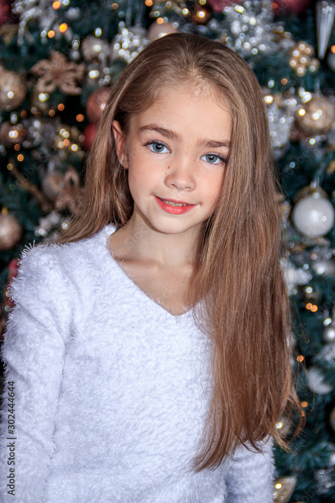 Little cute girl near the Christmas tree . New year and Christmas. Christmas tree decoration. Little cute girl near the Christmas tree . New year and Christmas. Christmas tree decoration.