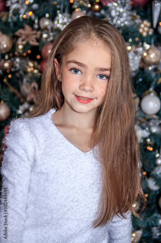 Little cute girl near the Christmas tree . New year and Christmas. Christmas tree decoration.