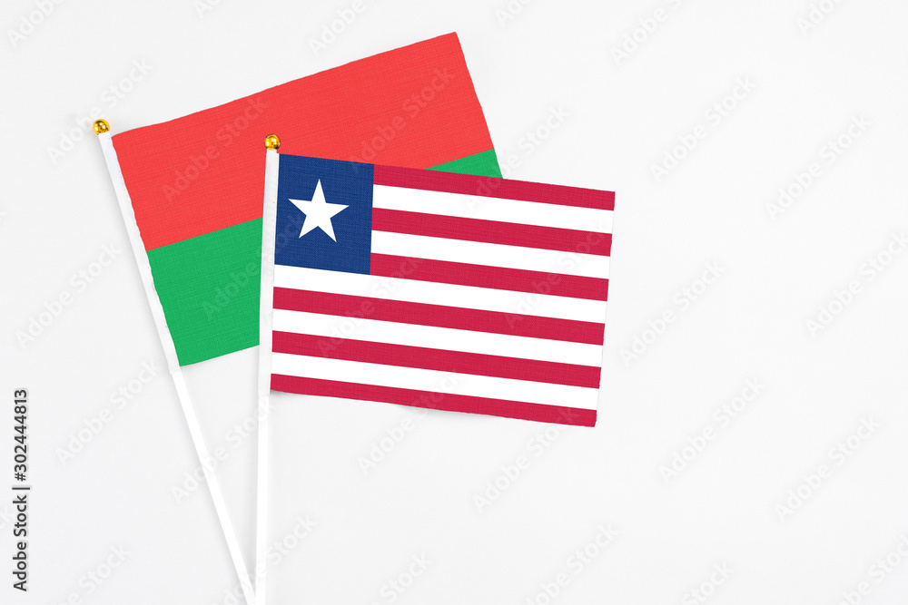 Liberia and Burkina Faso stick flags on white background. High quality fabric, miniature national flag. Peaceful global concept.White floor for copy space. Liberia and Burkina Faso stick flags on white background. High quality fabric, miniature national flag. Peaceful global concept.White floor for copy space.