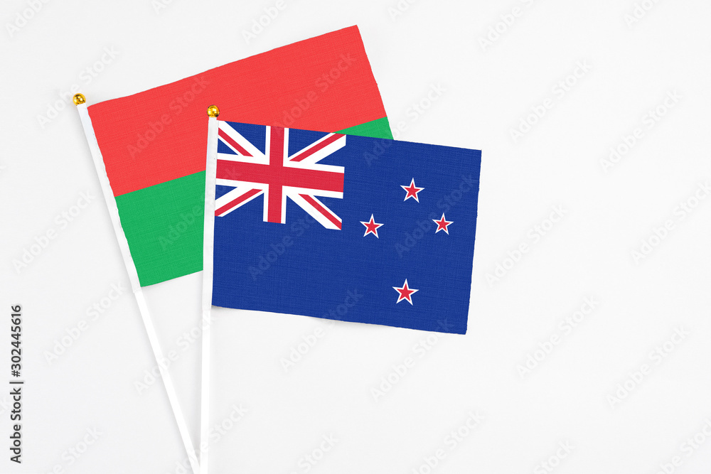 Fototapeta premium New Zealand and Burkina Faso stick flags on white background. High quality fabric, miniature national flag. Peaceful global concept.White floor for copy space.