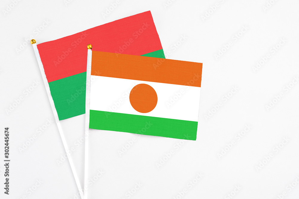 Niger and Burkina Faso stick flags on white background. High quality fabric, miniature national flag. Peaceful global concept.White floor for copy space. Niger and Burkina Faso stick flags on white background. High quality fabric, miniature national flag. Peaceful global concept.White floor for copy space.