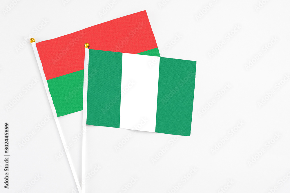 Nigeria and Burkina Faso stick flags on white background. High quality fabric, miniature national flag. Peaceful global concept.White floor for copy space. Nigeria and Burkina Faso stick flags on white background. High quality fabric, miniature national flag. Peaceful global concept.White floor for copy space.
