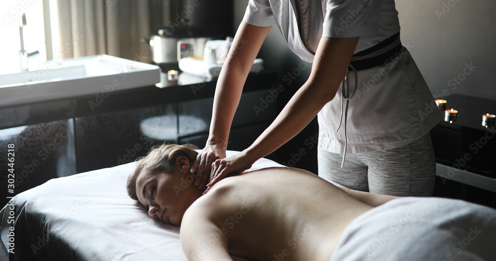 Obraz premium Young woman enjoying massage in spa salon